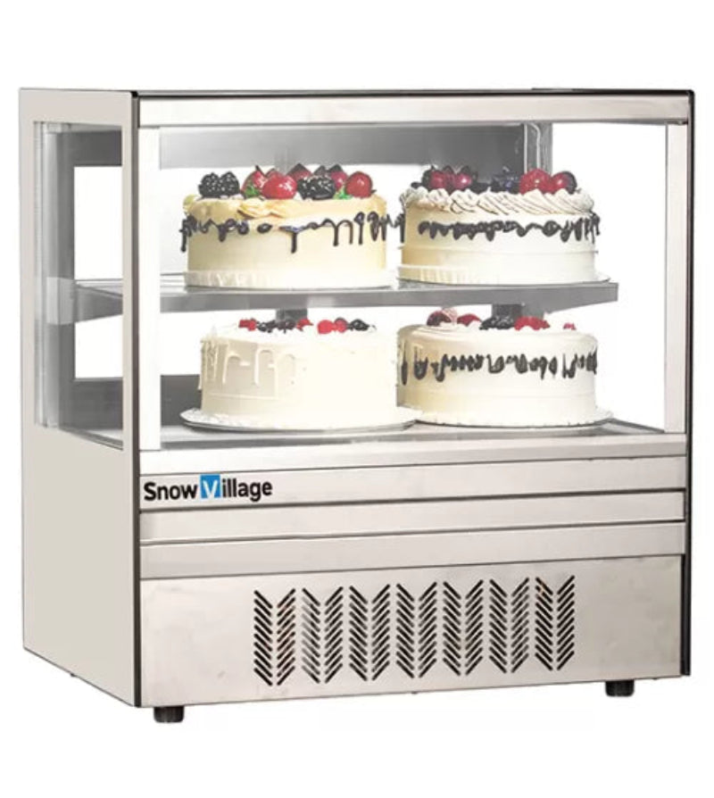 Snow Village cake display case with four iced cakes topped with berries on a white background