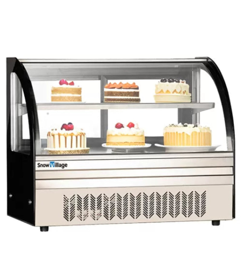 Display case with cakes on a white background, featuring the Snow Village brand.